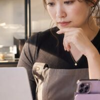 ネイルサロン集客の改善策を考えるネイリストと予約管理画面