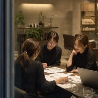 美容サロン 同業差別化 アイデアを考えるスタッフと、個性的なサービスや店内演出を検討する美容サロンの打ち合わせ風景