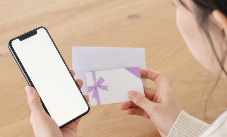 ホットペッパービューティーのギフト券がいつ届くかを確認するスマートフォンとギフトカードのイメージ