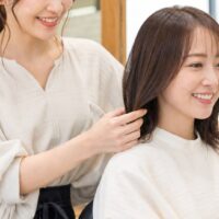 良い口コミ 例文 美容室を紹介する、笑顔で接客する美容師と仕上がりを確認するお客様のイメージ