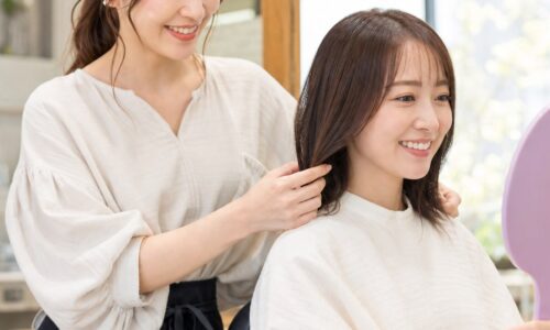 良い口コミ 例文 美容室を紹介する、笑顔で接客する美容師と仕上がりを確認するお客様のイメージ