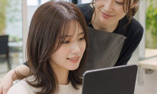 美容室口コミ例文を紹介する、ヘアサロンで施術後の仕上がりを確認する女性と美容師