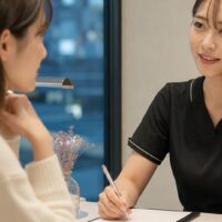 眉毛サロンの当日予約は迷惑か迷う女性と、予約対応をする眉毛サロンスタッフ