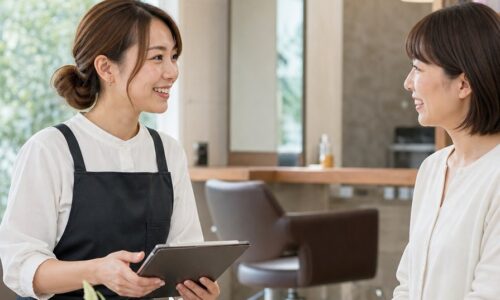サロン集客支援のメリットをイメージした、スタッフと顧客が笑顔で相談する美容サロンの店内