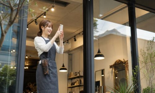 サロンのスタッフがスマートフォンでストーリーを発信し、予約につながる集客効果を高めるイメージ