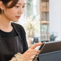 ホットペッパービューティーでリピーターを増やす方法を考える美容室スタッフと顧客管理画面