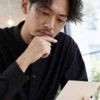 美容室の口コミ依頼カードの作り方を考える美容師と、自然な口コミ投稿を促すカード