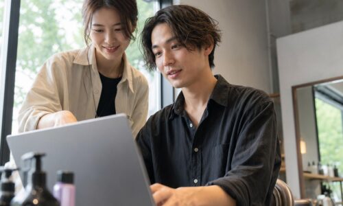 ヘアサロンの口コミ返信のコツを解説する美容師とパソコンのイメージ