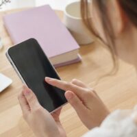 ミニモで同じ店を違う人に予約した場合の新規判定ルールを確認する女性